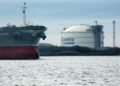 The Amazon Brilliance oil tanker sails past a storage tank at the Cheniere Energy Inc. liquefied natural gas (LNG) terminal in Sabine Pass, Louisiana, U.S., on Thursday, Jan. 14, 2016. Cheniere Energy Inc. said its first cargo of LNG from its new Louisiana export terminal will be delayed by as much as two months because of faulty wiring. Photographer: F. Carter Smith/Bloomberg via Getty Images